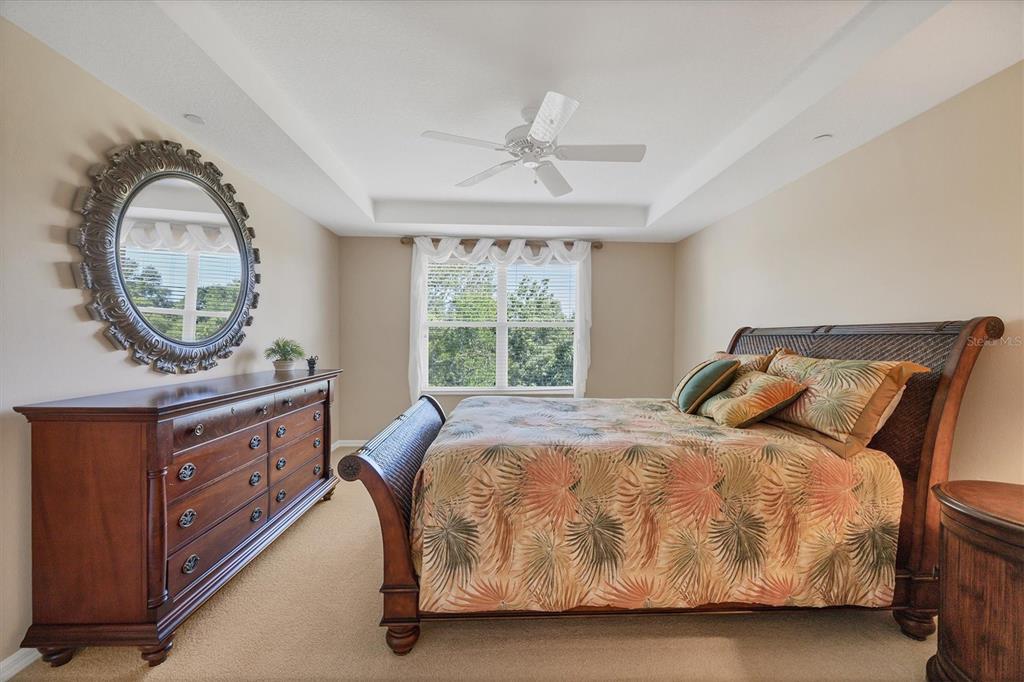 7115 Boca Grove Place, Unit 204 Lakewood Ranch, FL 34202 - Photo 19 of 40 a bed sitting in a bedroom next to a window