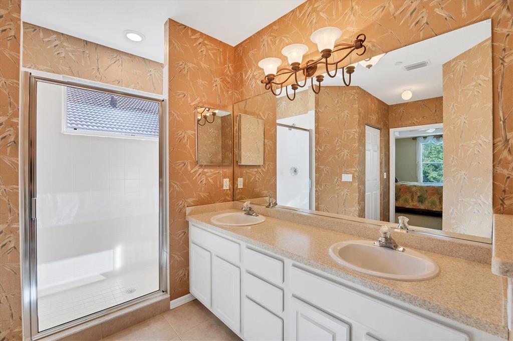 7115 Boca Grove Place, Unit 204 Lakewood Ranch, FL 34202 - Photo 20 of 40 a bathroom with a granite countertop sink a mirror and a shower