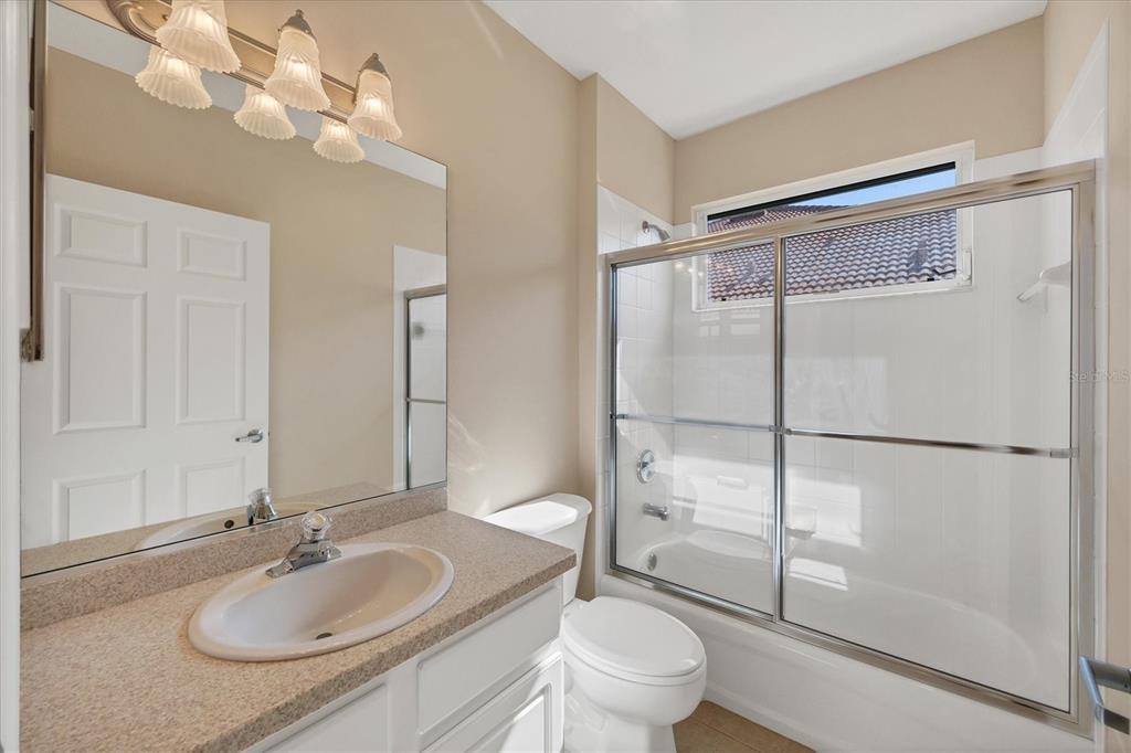 7115 Boca Grove Place, Unit 204 Lakewood Ranch, FL 34202 - Photo 22 of 40 a bathroom with a granite countertop sink toilet a mirror and shower