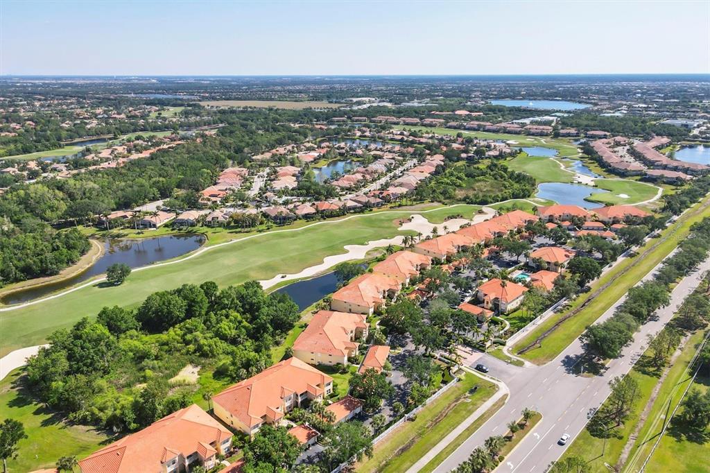 7115 Boca Grove Place, Unit 204 Lakewood Ranch, FL 34202 - Photo 3 of 40 an aerial view of a city with lots of residential buildings ocean and mountain view in back