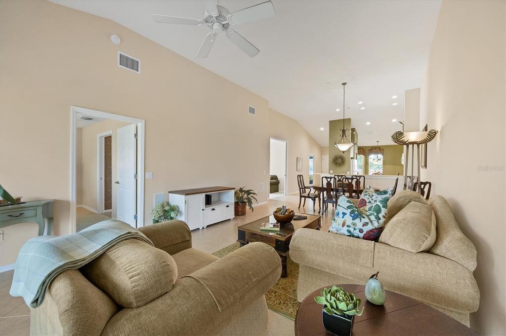 7115 Boca Grove Place, Unit 204 Lakewood Ranch, FL 34202 - Photo 6 of 40 a living room with furniture and a chandelier