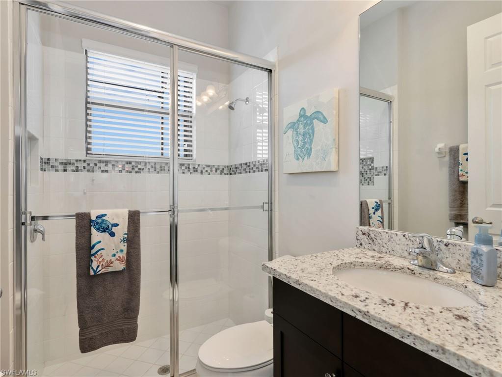 2756 Crystal Way Naples, FL 34119 - Photo 18 of 50 a bathroom with a granite countertop sink toilet and shower