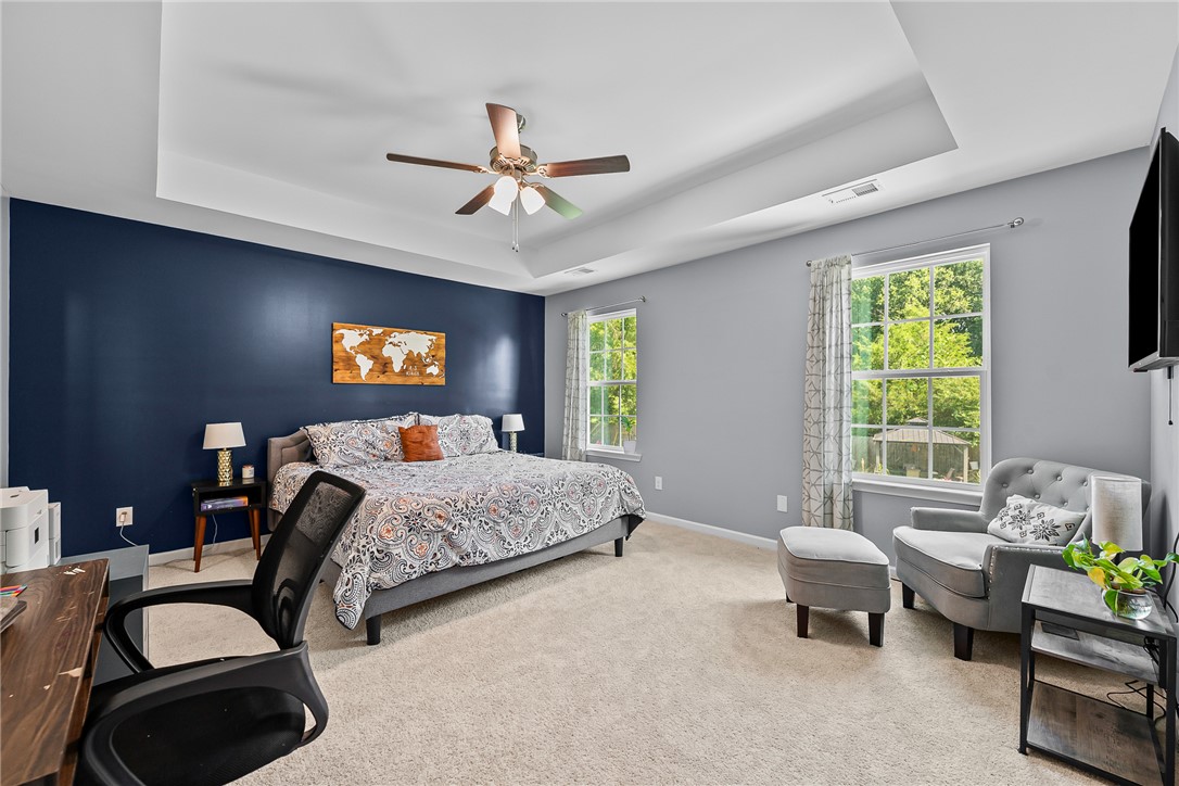 719 Camberwell Road Simpsonville, SC 29680 - Photo 14 of 47 Plentiful natural light streams through multiple windows into this spacious bedroom featuring tray ceiling details.