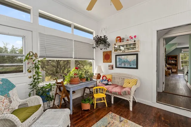 a bed room with a bed a table and a large window