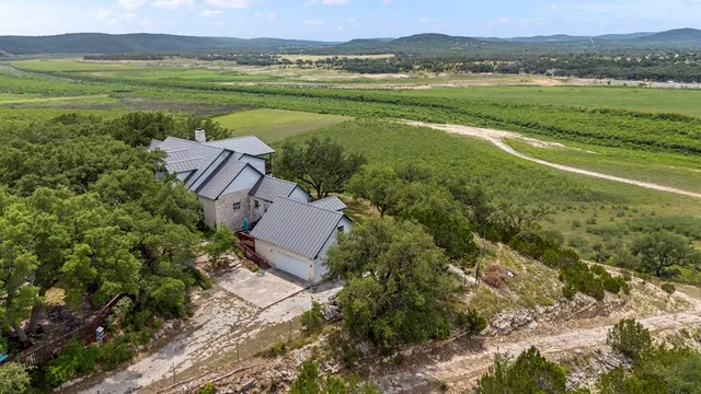 an aerial view of residential houses with outdoor space and trees