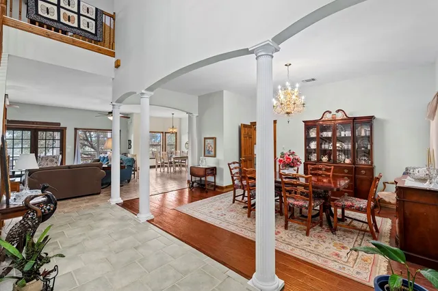 a living room with furniture a chandelier and a rug