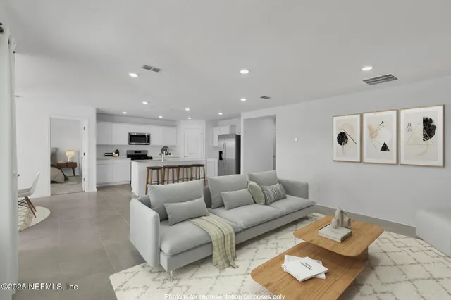 a view of kitchen with stainless steel appliances refrigerator oven and white cabinets