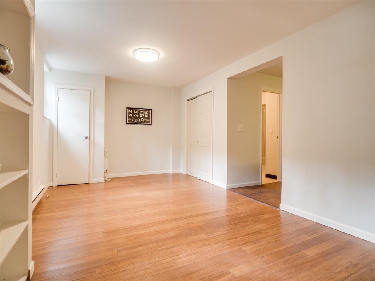 226 Christopher Columbus Drive, Unit 1 Jersey City, NJ 07302 - Photo 2 of 8 a view of an empty room with wooden floor