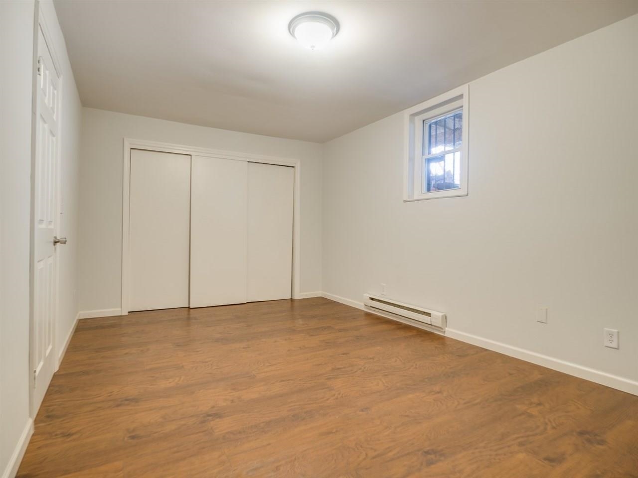 226 Christopher Columbus Drive, Unit 1 Jersey City, NJ 07302 - Photo 4 of 8 an empty room with windows