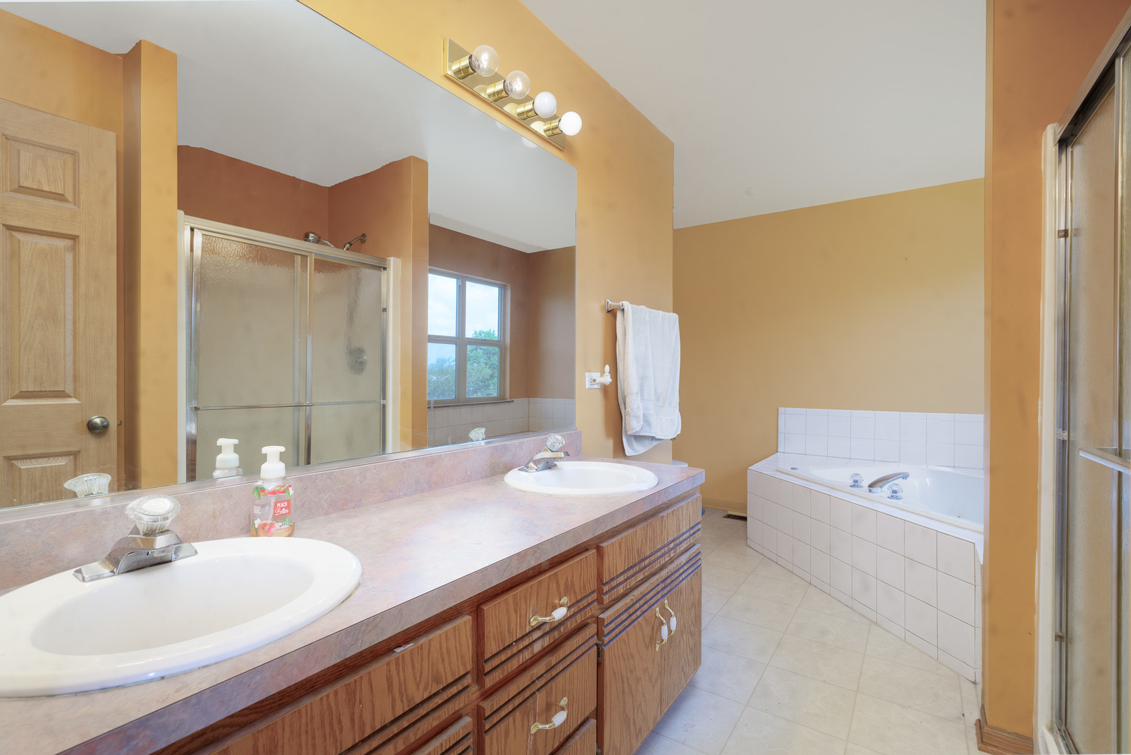 2104 Olde Mill Road Plainfield, IL 60586 - Photo 14 of 23 a bathroom with a sink a tub and a mirror