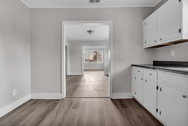 a view of empty room with wooden floor