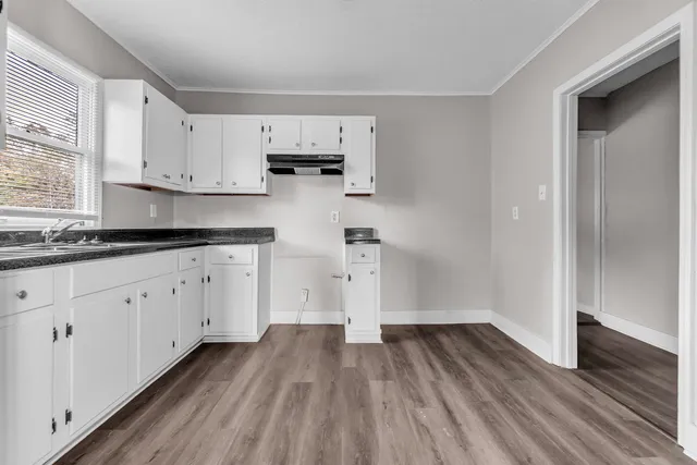 a kitchen with wooden floor and white appliances
