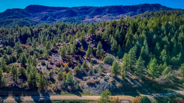 a view of a large building with a yard and mountain in the background