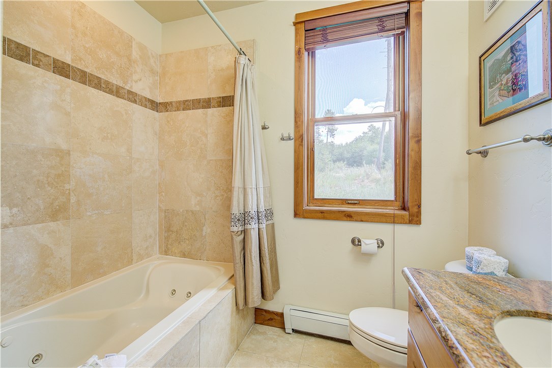 65 Antler Gulch Road, Unit 506 Keystone, CO 80435 - Photo 10 of 15 Master Bath with jetted tub, granite slab vanity, travertine tile