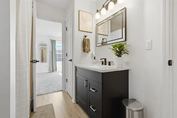 a bathroom with a sink vanity toilet and shower