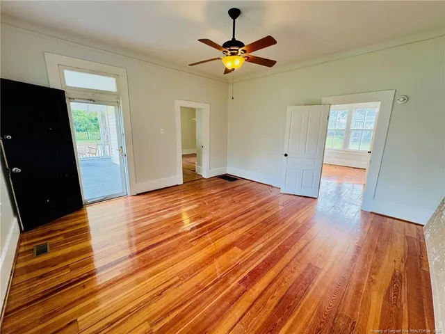 a view of an empty room with wooden floor