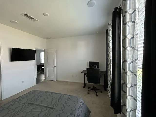 a bedroom with a bed and a flat screen tv
