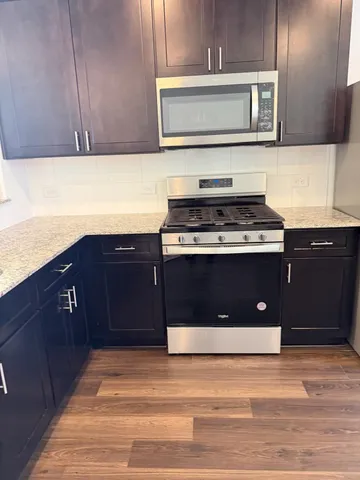 a kitchen with stainless steel appliances granite countertop a stove a microwave and a sink