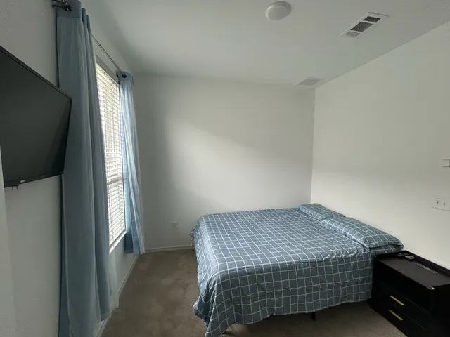 a bedroom with a bed and a window