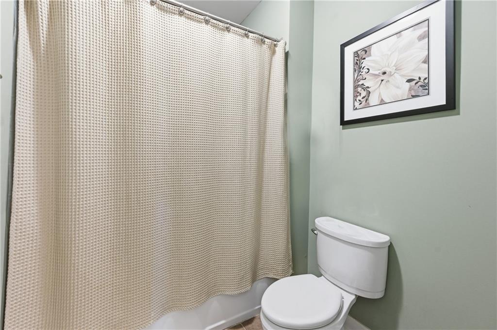 117 South Bay Road, Unit 402 Eatonton, GA 31024 - Photo 13 of 48 a white toilet sitting next to a shower curtain