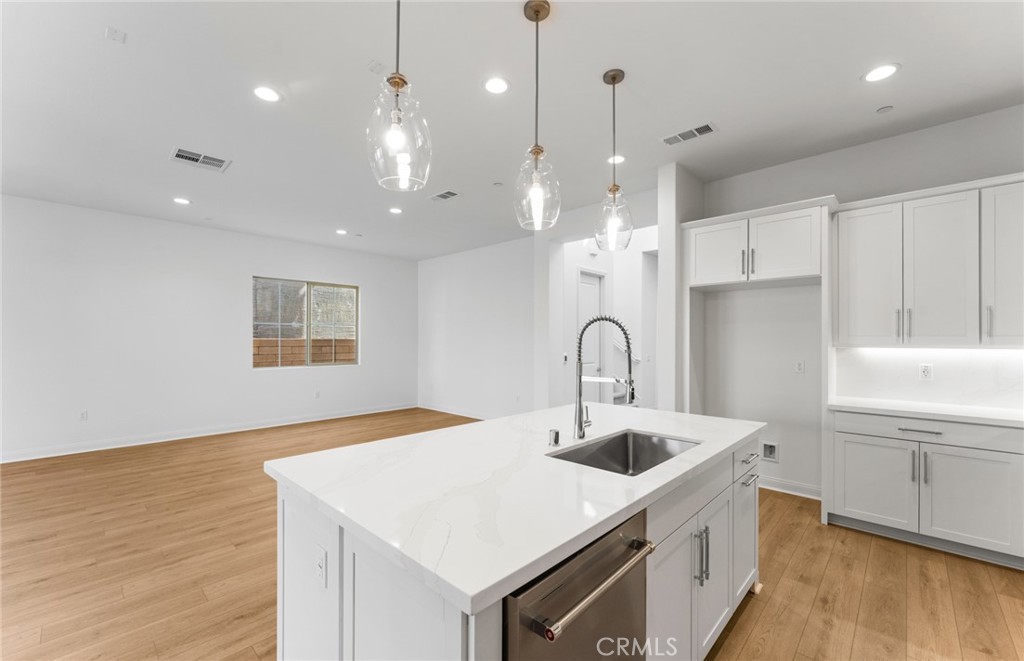 743 Corkscrew Road Rancho Mission Viejo, CA 92694 - Photo 13 of 35 a kitchen with a sink a kitchen island and stainless steel appliances