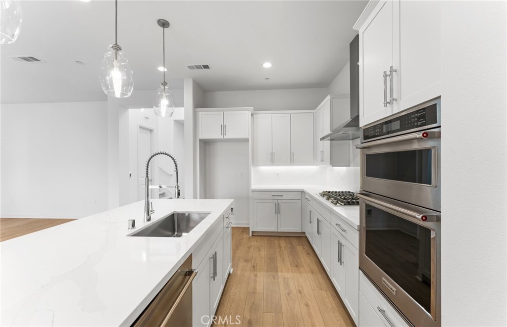 743 Corkscrew Road Rancho Mission Viejo, CA 92694 - Photo 14 of 35 a kitchen with white cabinets stainless steel appliances and sink
