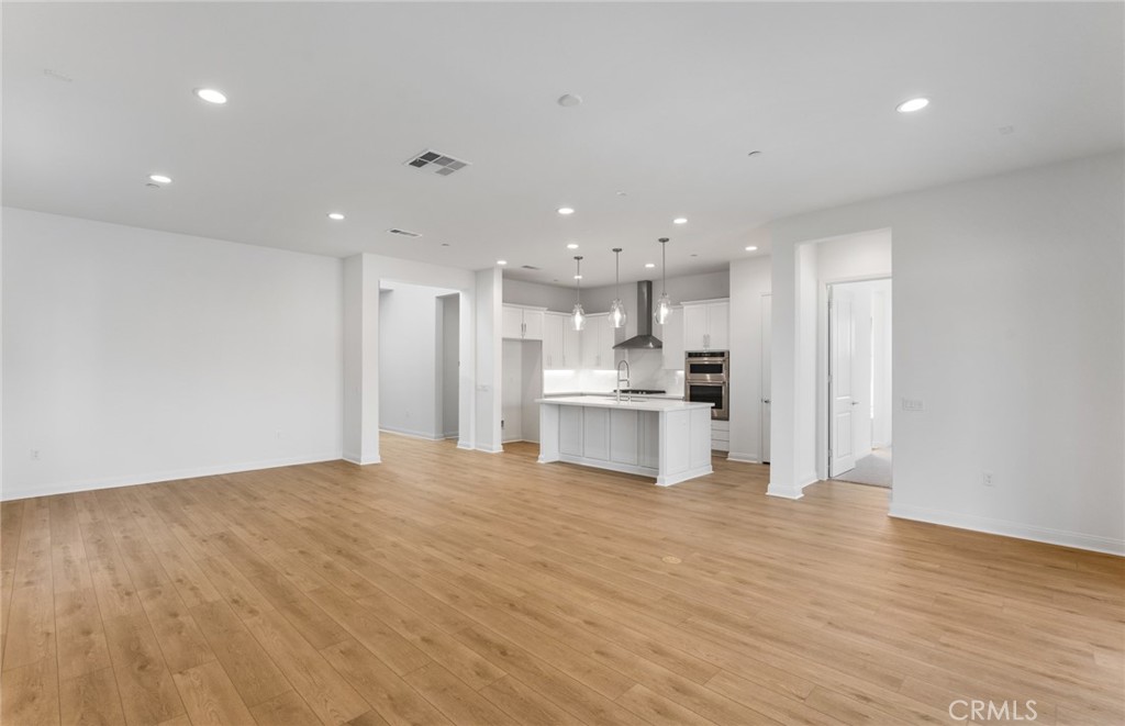 743 Corkscrew Road Rancho Mission Viejo, CA 92694 - Photo 4 of 35 a view of kitchen with kitchen island a sink wooden floor and a refrigerator