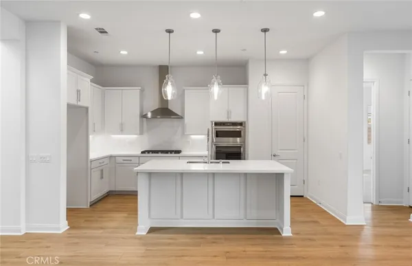 a kitchen with kitchen island a sink stainless steel appliances and cabinets