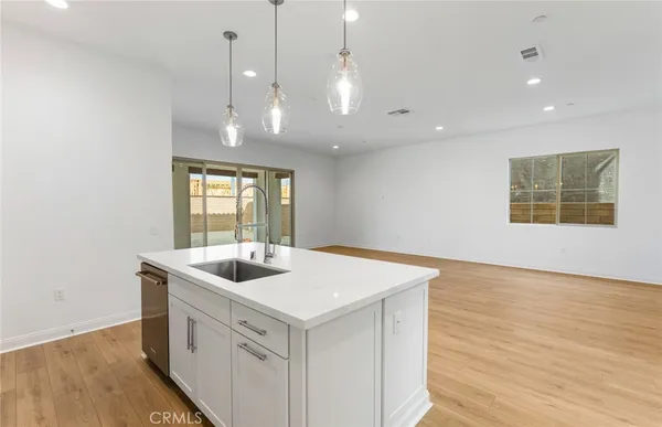 a kitchen that has a sink a stove and a wooden floor