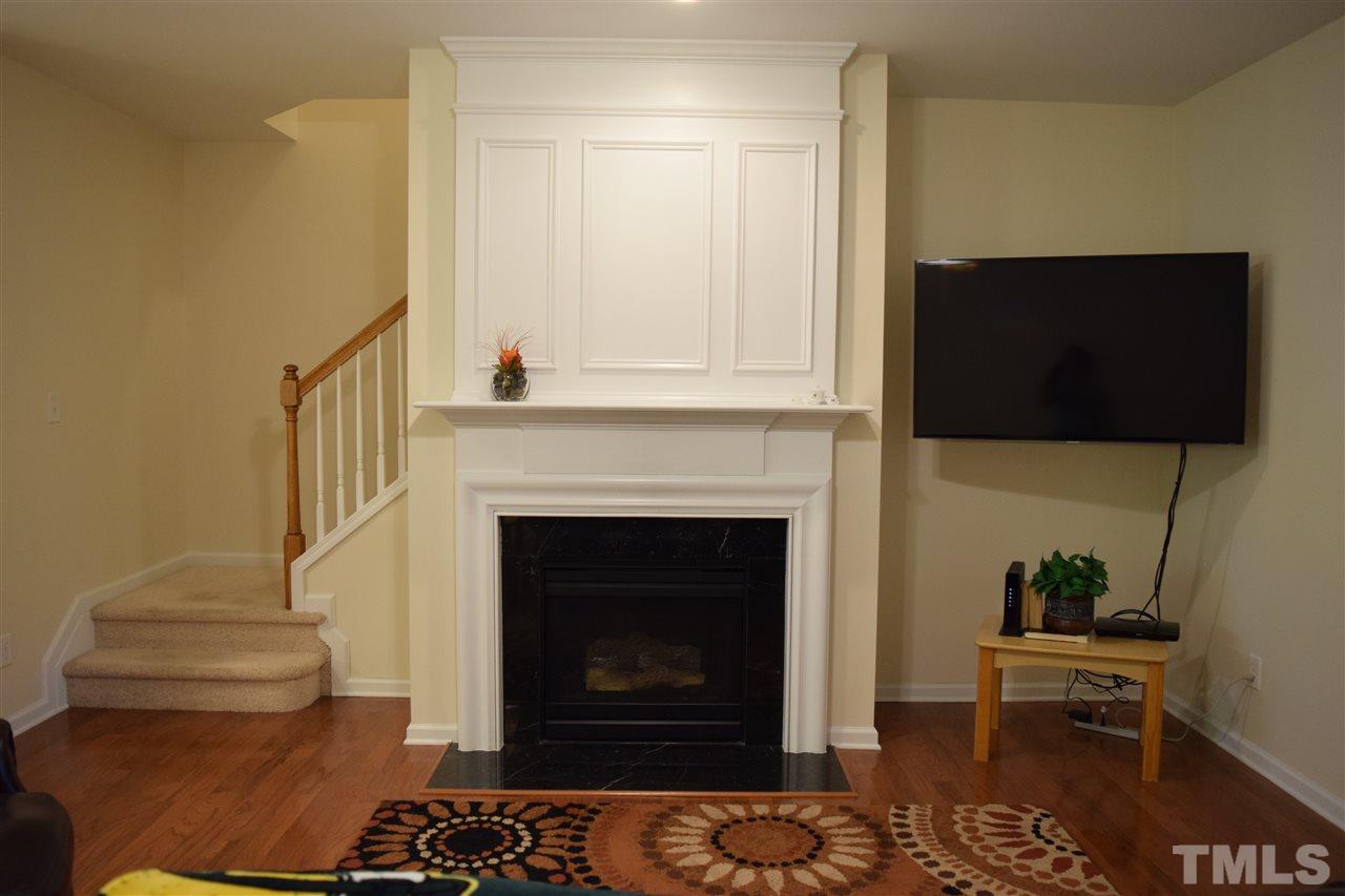 8702 Redcrest Place Raleigh, NC 27617 - Photo 2 of 22 a living room with a fireplace and a flat screen tv