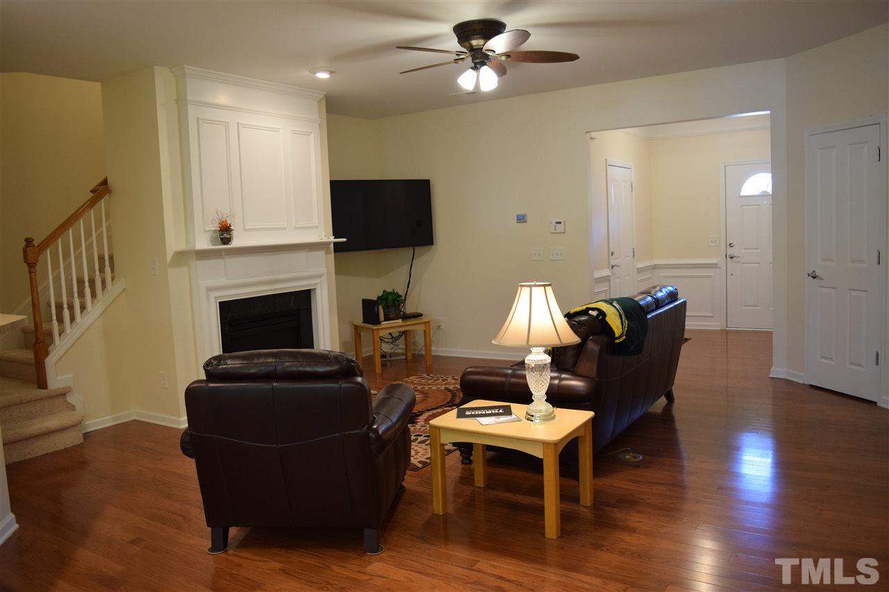 8702 Redcrest Place Raleigh, NC 27617 - Photo 20 of 22 a living room with furniture a flat screen tv and a fireplace