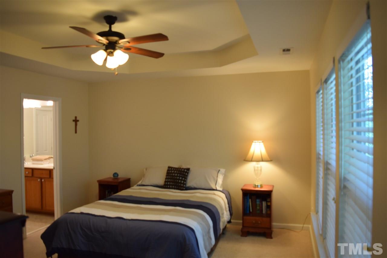 8702 Redcrest Place Raleigh, NC 27617 - Photo 6 of 22 a bedroom with a bed and a chandelier