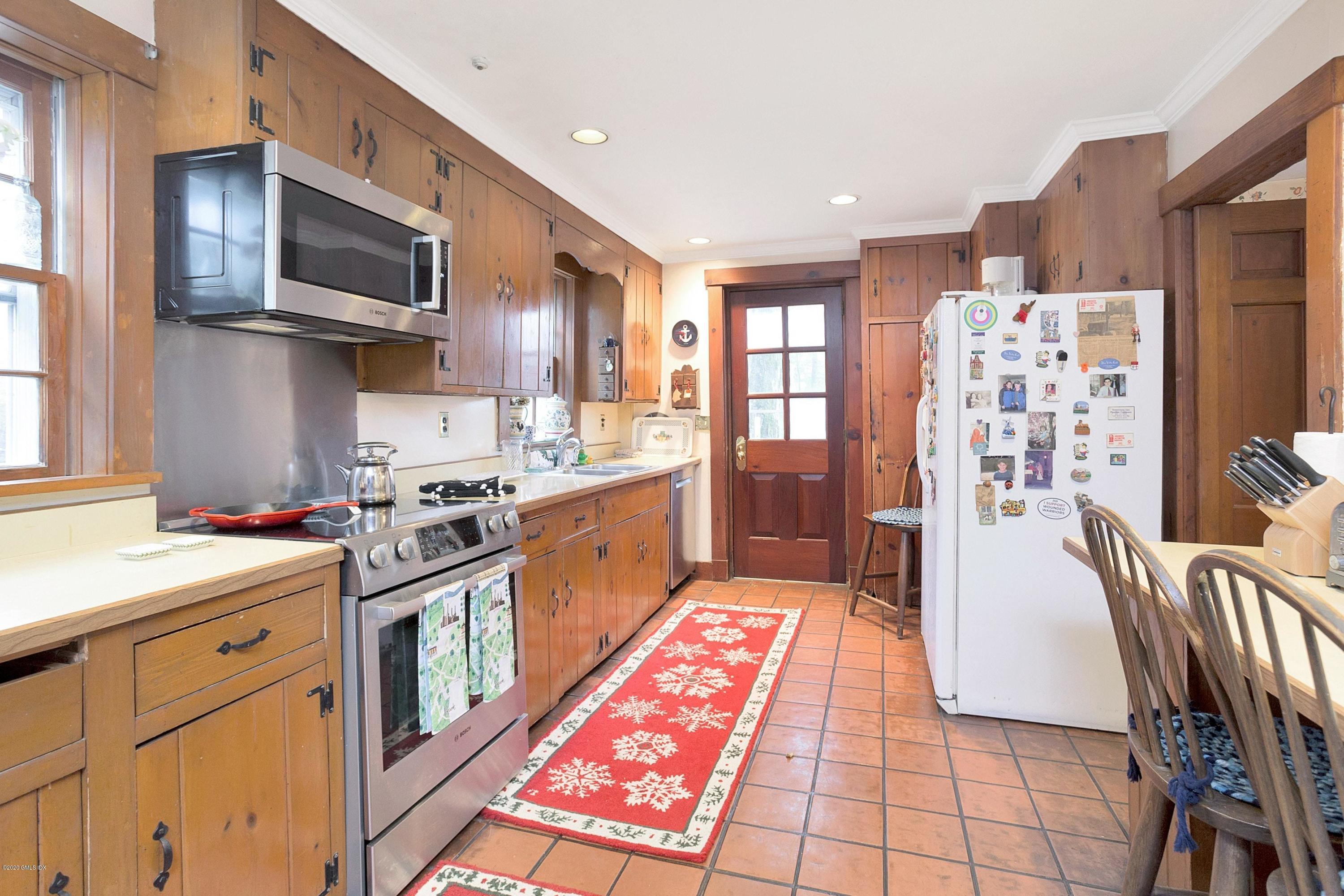207 Round Hill Road Greenwich, CT 06831 - Photo 10 of 28 a kitchen with stainless steel appliances kitchen island granite countertop a sink stove top oven and cabinets