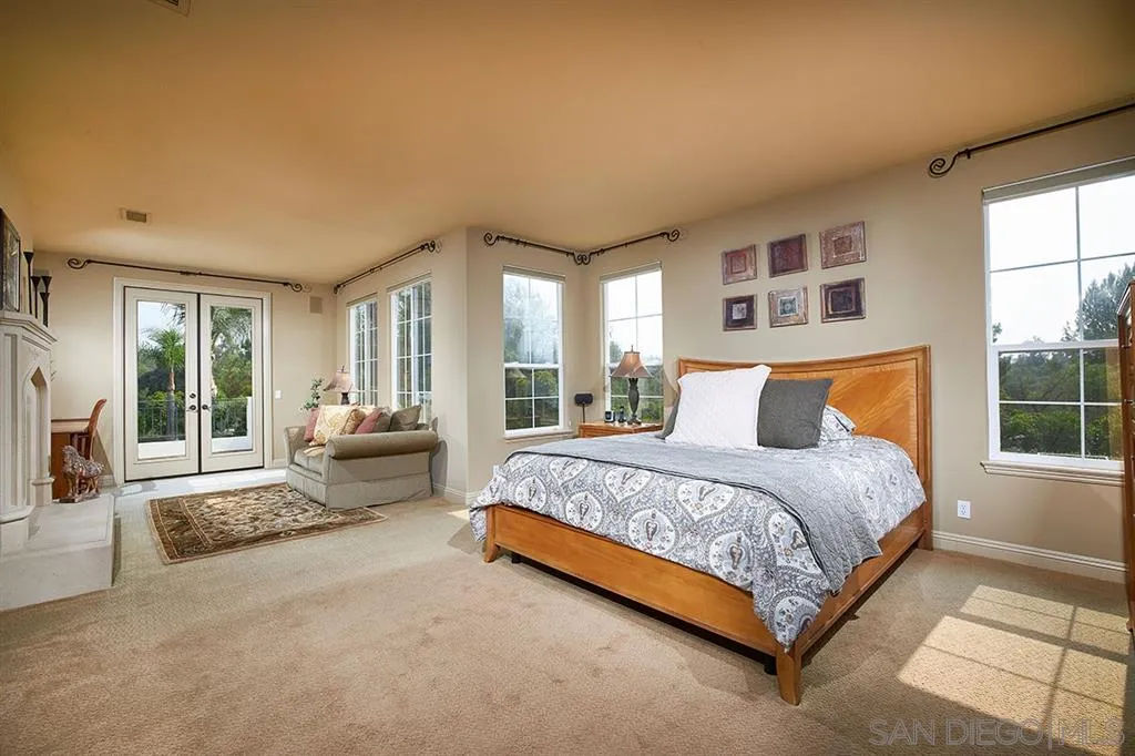 13625 Ash Hollow Crossing Road Poway, CA 92064 - Photo 16 of 25 a spacious bedroom with a bed and glass walk in closet