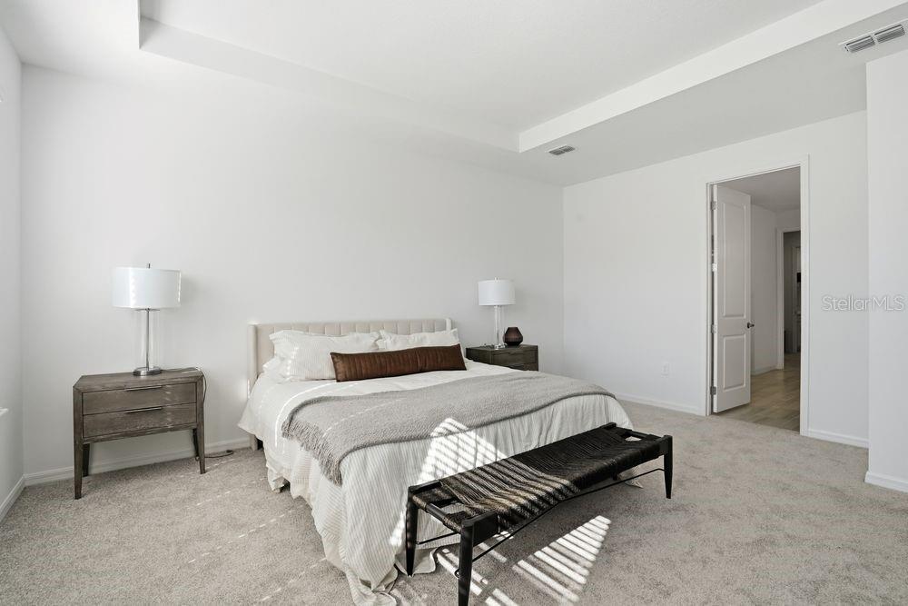 14242 Sawmill Street Parrish, FL 34219 - Photo 13 of 41 a bedroom with a bed and a lamp on table