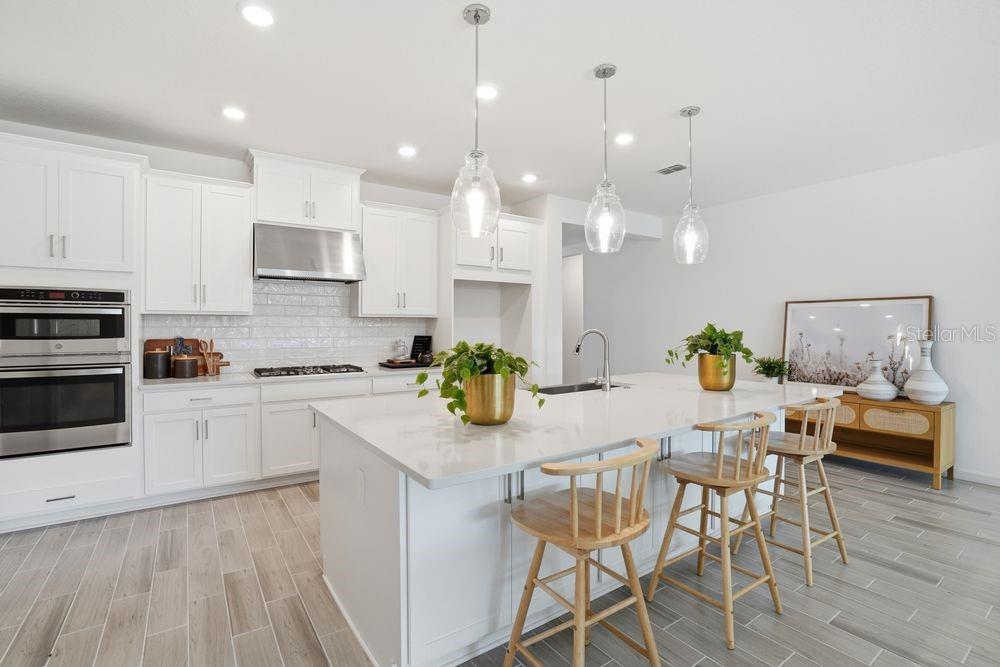 14242 Sawmill Street Parrish, FL 34219 - Photo 3 of 41 a kitchen with stainless steel appliances kitchen island granite countertop a stove a sink and a refrigerator