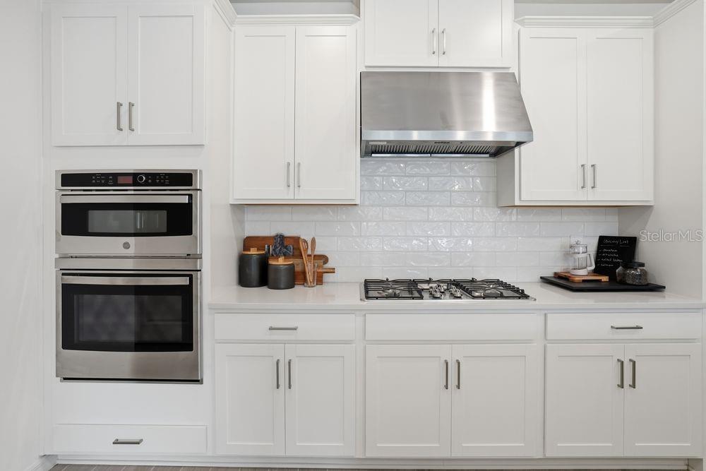 14242 Sawmill Street Parrish, FL 34219 - Photo 8 of 41 a kitchen with white cabinets and appliances