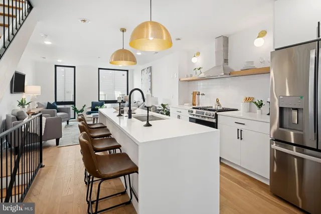 a kitchen with stainless steel appliances a sink a stove a refrigerator and cabinets