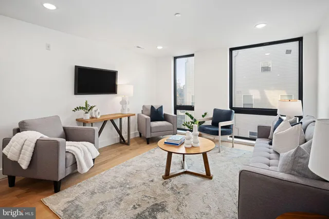 a living room with furniture and a wooden floor