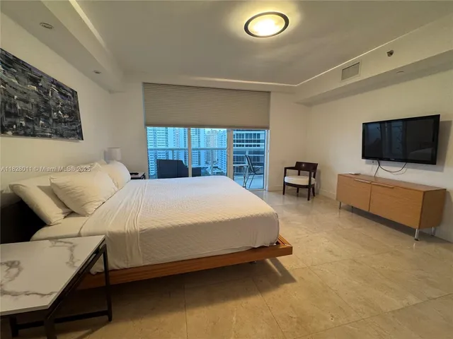 a bedroom with a large bed and a flat screen tv