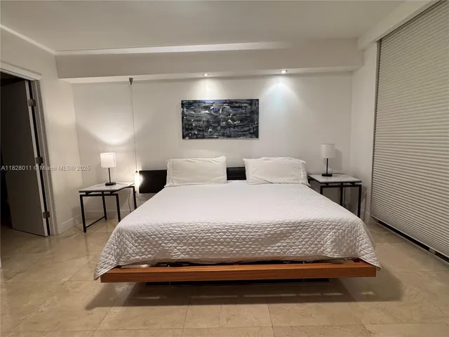 a bedroom with a bed a couch and paintings on the wall