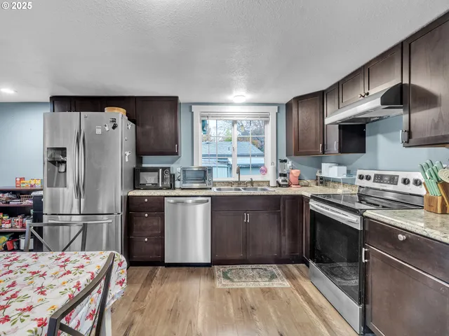 a kitchen with a sink refrigerator and microwave