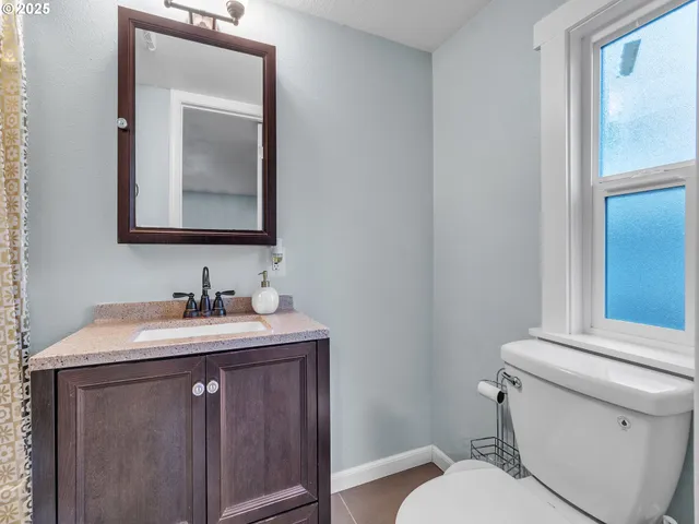 a bathroom with a toilet sink vanity and mirror