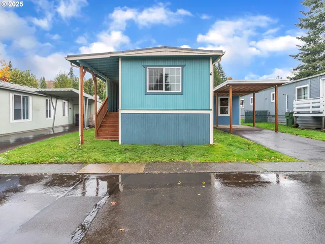 a front view of a house with a yard and potted plants