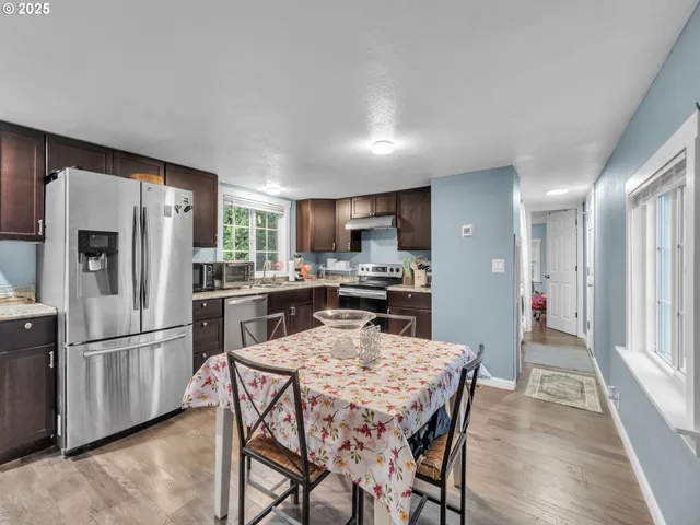 a kitchen with stainless steel appliances wooden floor and refrigerator