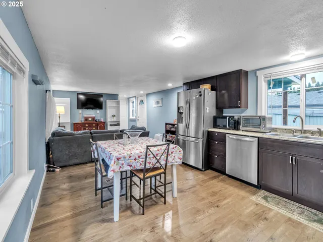a kitchen with a table chairs refrigerator and microwave