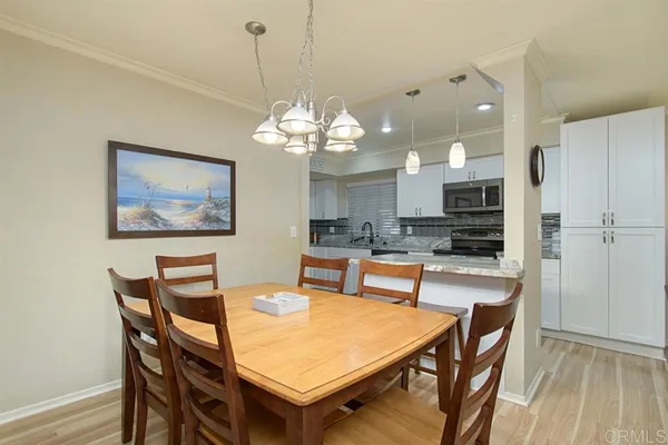 a dining room filled chandelier and wooden floor