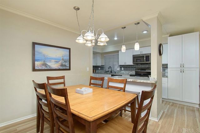 a dining room filled chandelier and wooden floor