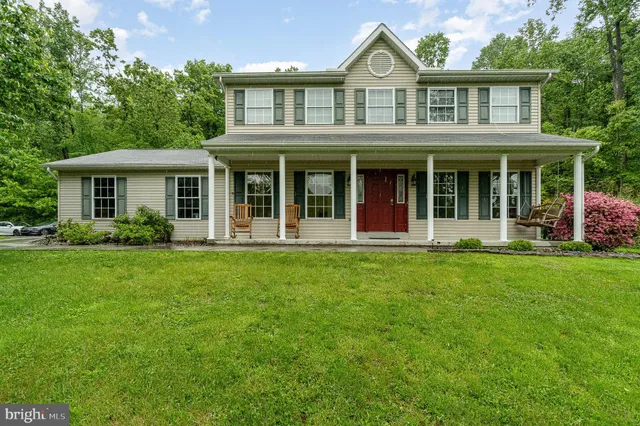a view of a house with a yard and potted plants
