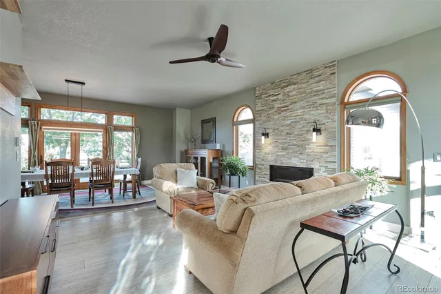 a living room with fireplace furniture and a large window